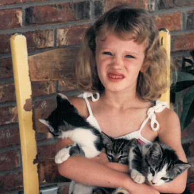 Childhood photo of BrandFuel employee Allison McLain holding a cat.