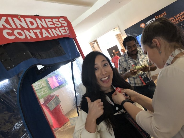 Lady putting up the "thumbs up" gesture in front of the Kindness Container.
