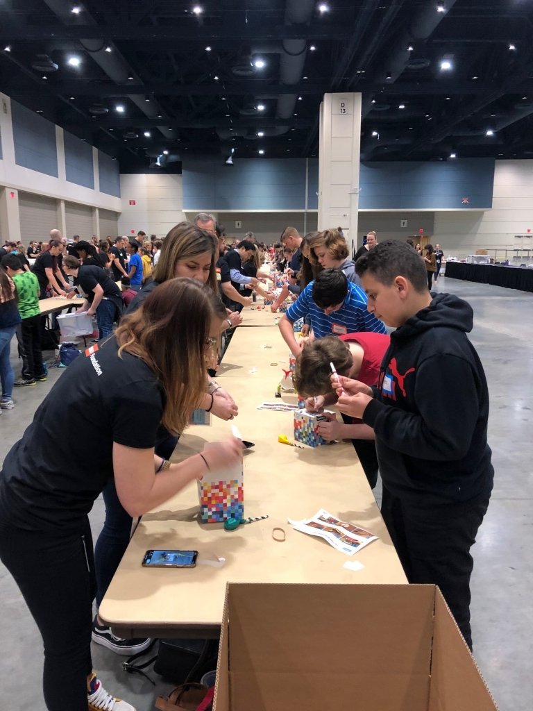 People working at a table during a "BrandGood" event.