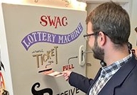 A man inserting a ticket into a makeshift lottery machine.