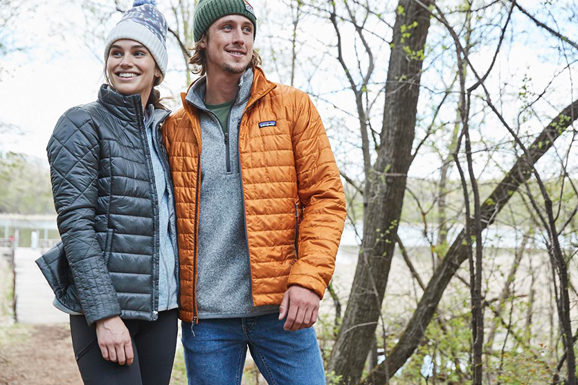 A woman and man wearing Patagonia jackets while hiking.