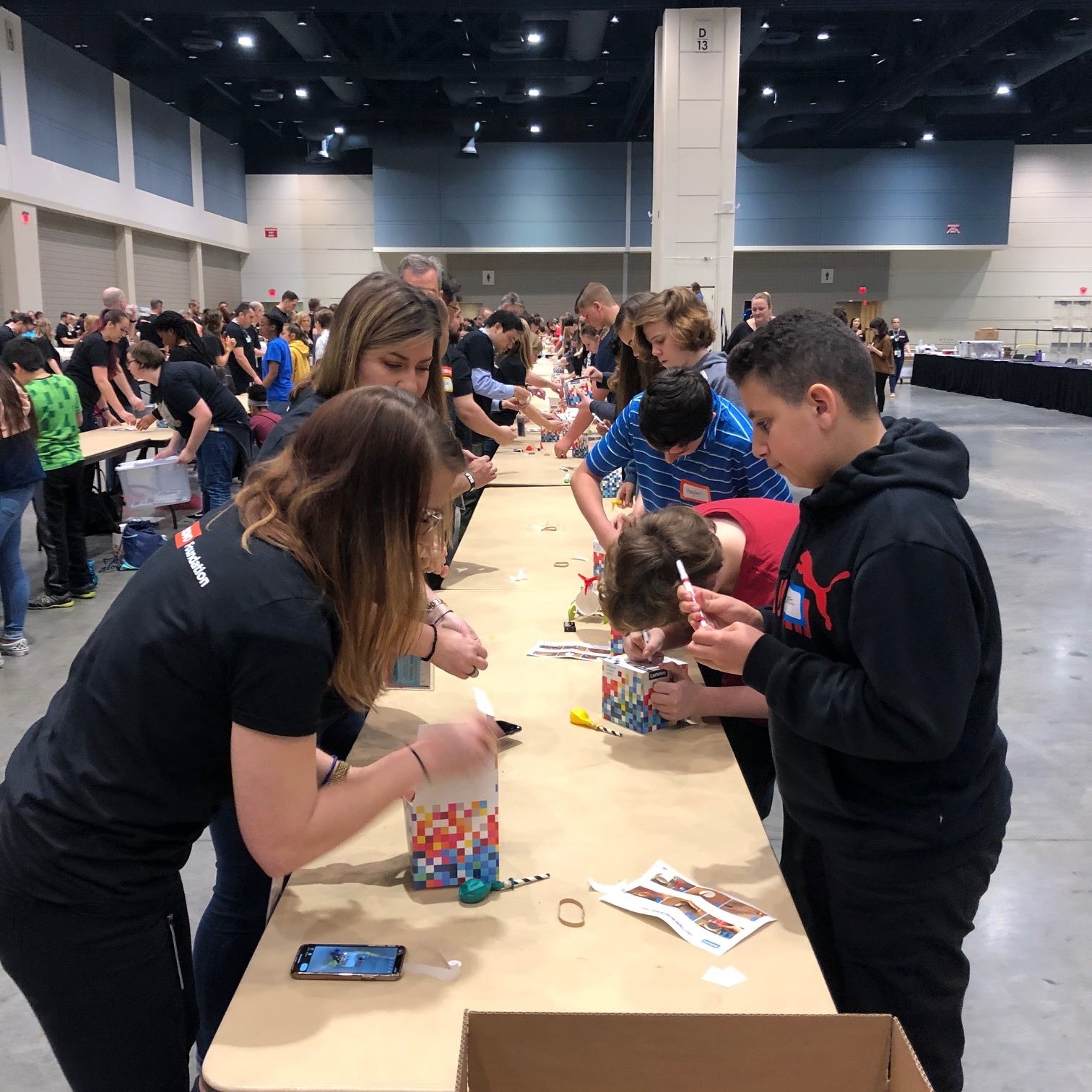People working at a table during a "BrandGood" event.